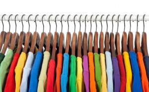 Multicolored clothes on wooden hangers